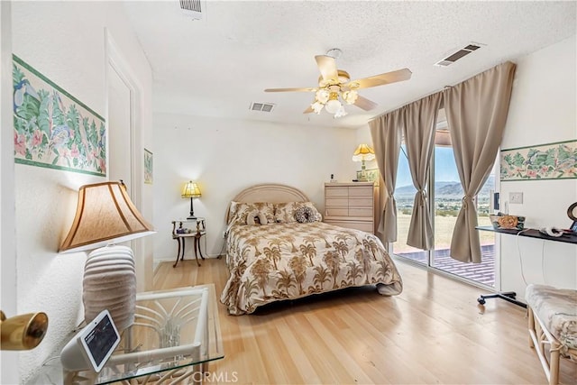 6333 Carodean Rd Unit 29, Palms, CA 92277 - bedroom with access to outside, wood finished floors, ceiling fan, and a textured ceiling