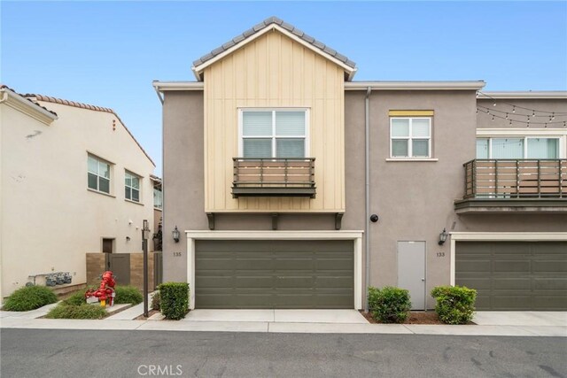 135 Acamar, Irvine, CA 92618 - townhome / multi-family property featuring a balcony, stucco siding, an attached garage, and board and batten siding