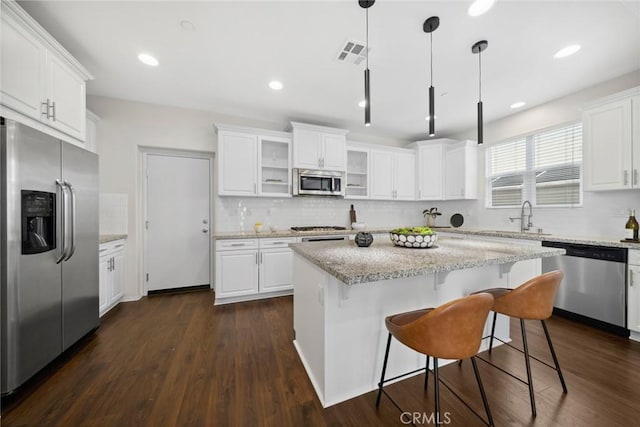 135 Acamar, Irvine, CA 92618 - kitchen with stainless steel appliances, decorative backsplash, white cabinetry, a kitchen bar, and recessed lighting
