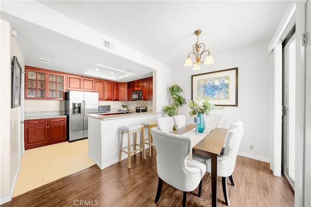 67 Remington Unit 231, Irvine, CA 92620 - dining room with a chandelier, light wood-style flooring, and a tray ceiling