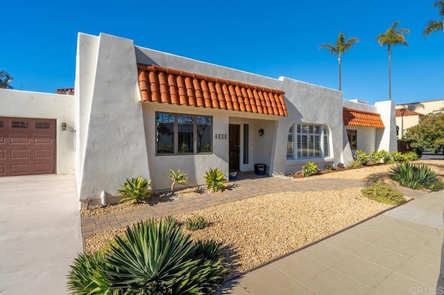 4280 Trias St, San Diego, CA 92103 - view of front of house featuring a tiled roof, a garage, driveway, and stucco siding