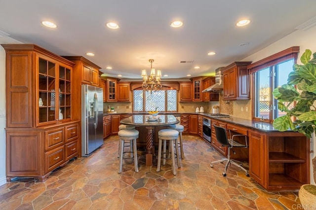 4280 Trias St, San Diego, CA 92103 - kitchen with stainless steel appliances, brown cabinetry, wall chimney range hood, a chandelier, and recessed lighting