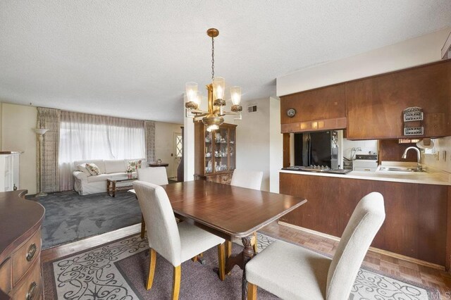 1113 Camino Del Sol Cir, Carlsbad, CA 92008 - dining area with a chandelier, a textured ceiling, and light wood-style floors