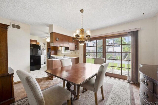 1113 Camino Del Sol Cir, Carlsbad, CA 92008 - dining space featuring a chandelier, a textured ceiling, and a ceiling fan