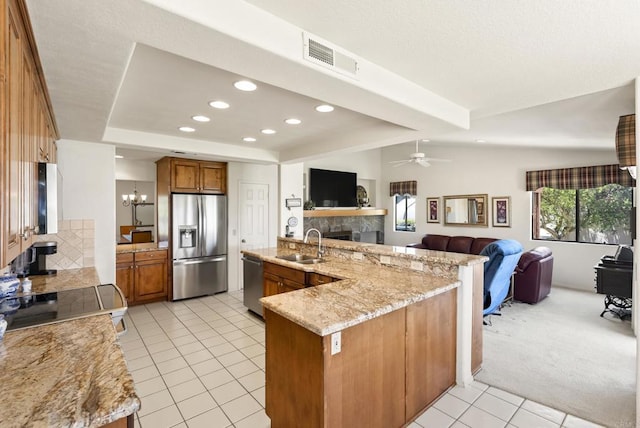 2221 Cortina Cir, Escondido, CA 92029 - kitchen with stainless steel appliances, open floor plan, brown cabinets, a fireplace, and recessed lighting