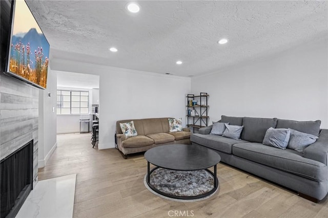 434 S Los Robles Ave Unit 4, Pasadena, CA 91101 - living area with light wood-style floors, a fireplace, a textured ceiling, recessed lighting, and ornamental molding