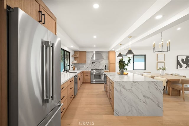 4016 Old Topanga Canyon Rd, Calabasas, CA 91302 - kitchen featuring high quality appliances, wall chimney exhaust hood, tasteful backsplash, light wood-type flooring, and a kitchen island