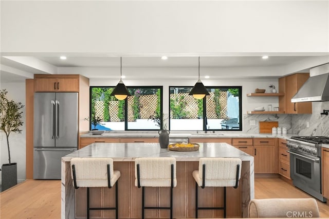 4016 Old Topanga Canyon Rd, Calabasas, CA 91302 - kitchen with high end appliances, wall chimney exhaust hood, tasteful backsplash, light wood-style flooring, and recessed lighting