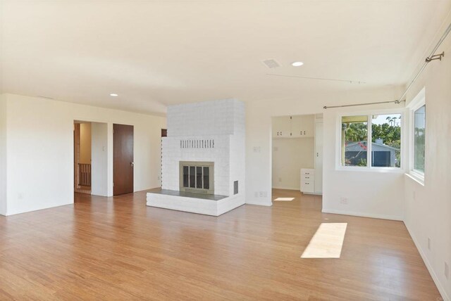 5884 Redondo Dr, Bonsall, CA 92003 - unfurnished living room with light wood-style flooring, recessed lighting, and a brick fireplace