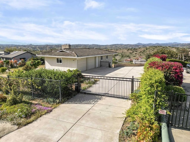 5884 Redondo Dr, Bonsall, CA 92003 - view of front facade featuring a gate, concrete driveway, a mountain view, and an attached garage