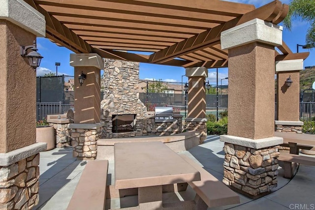 12737 Savannah Creek Dr Unit 280, San Diego, CA 92128 - view of patio / terrace with an outdoor stone fireplace, a pergola, and an outdoor kitchen