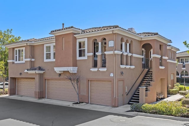 12737 Savannah Creek Dr Unit 280, San Diego, CA 92128 - view of front of property with an attached garage, stucco siding, stairs, a tiled roof, and driveway