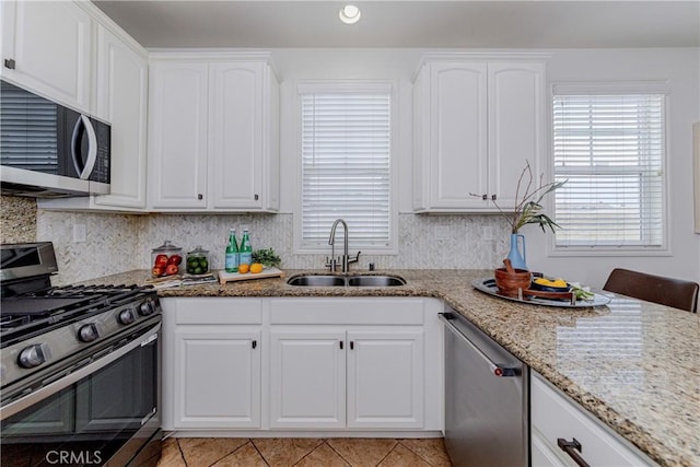 8647 Belmont St, Cypress, CA 90630 - kitchen featuring appliances with stainless steel finishes, light stone countertops, white cabinets, light tile patterned floors, and recessed lighting