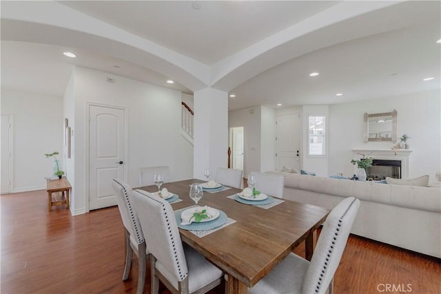 8647 Belmont St, Cypress, CA 90630 - dining room featuring wood finished floors, recessed lighting, arched walkways, a fireplace, and stairway