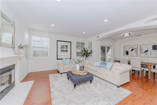 8647 Belmont St, Cypress, CA 90630 - living area featuring arched walkways, light wood-type flooring, recessed lighting, and a glass covered fireplace