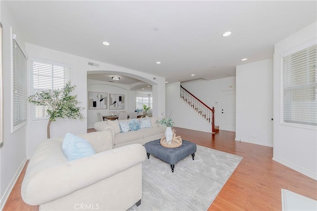8647 Belmont St, Cypress, CA 90630 - living area featuring arched walkways, stairs, light wood-style floors, and recessed lighting