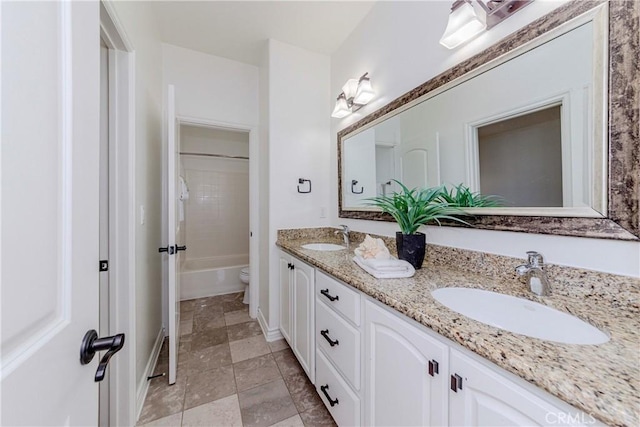 8647 Belmont St, Cypress, CA 90630 - bathroom featuring double vanity, washtub / shower combination, and stone finish flooring