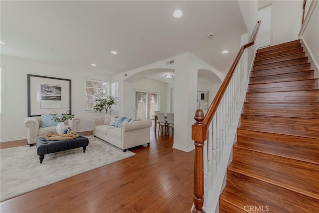 8647 Belmont St, Cypress, CA 90630 - living area featuring arched walkways, stairway, recessed lighting, and wood finished floors