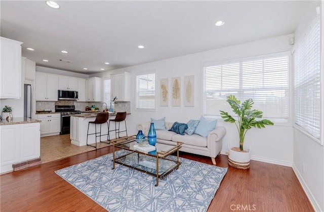 8647 Belmont St, Cypress, CA 90630 - living area featuring light wood-style flooring and recessed lighting
