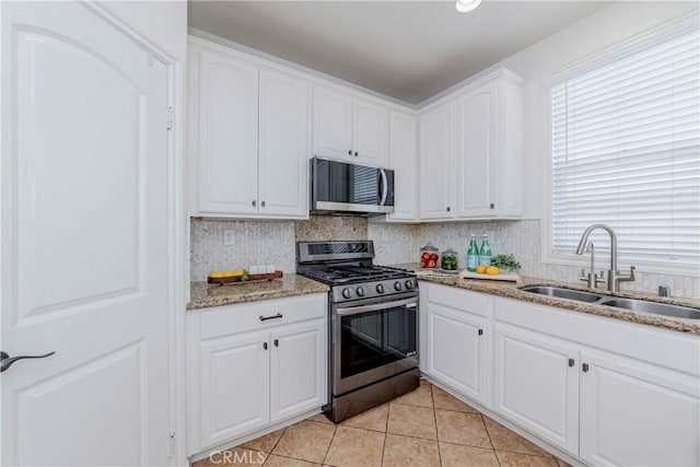8647 Belmont St, Cypress, CA 90630 - kitchen with appliances with stainless steel finishes, white cabinetry, light tile patterned floors, and light stone counters