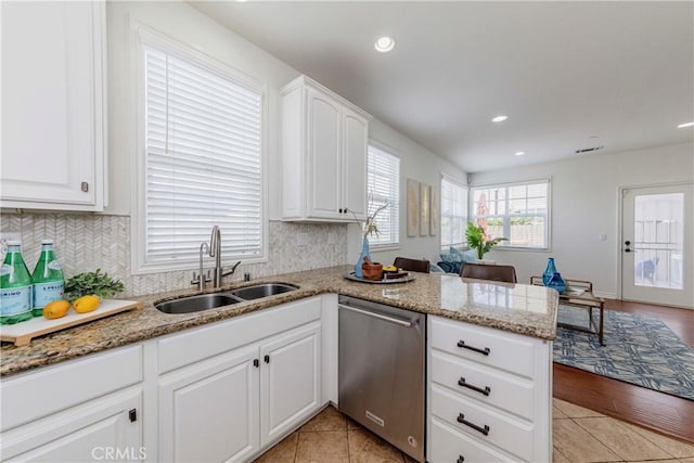 8647 Belmont St, Cypress, CA 90630 - kitchen with stainless steel dishwasher, light stone counters, backsplash, a peninsula, and white cabinetry