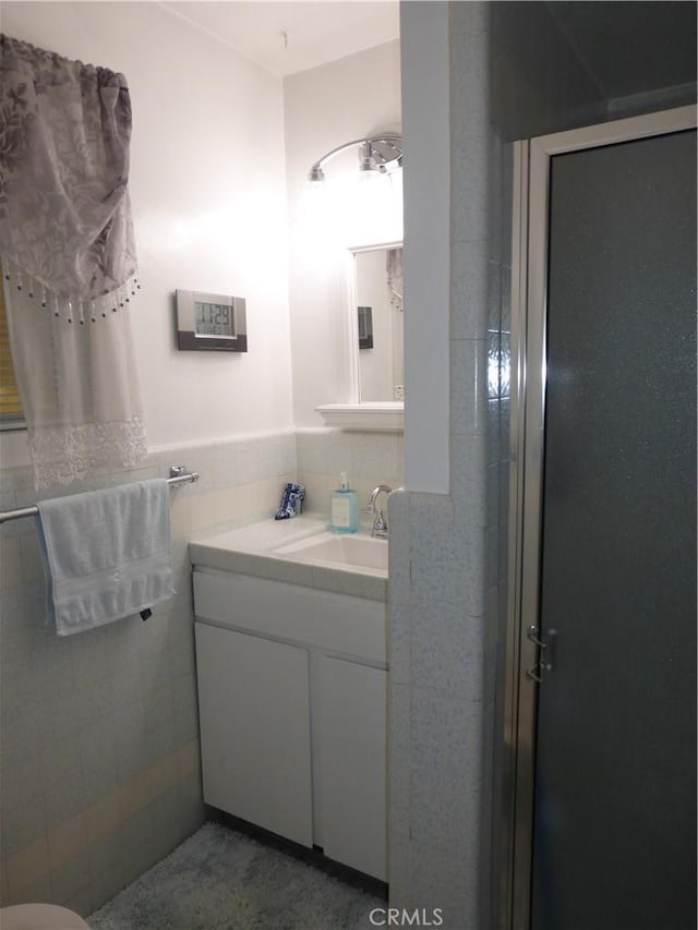 7106 Elmwood Rd, San Bernardino, CA 92404 - bathroom featuring vanity, tile walls, and wainscoting