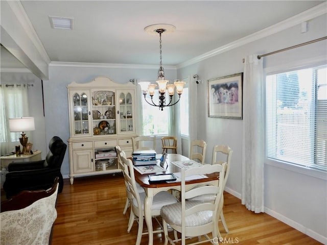 7106 Elmwood Rd, San Bernardino, CA 92404 - dining area with a chandelier, plenty of natural light, wood finished floors, and ornamental molding
