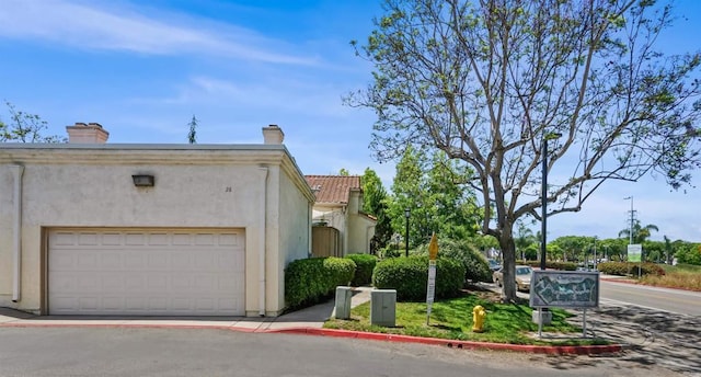 750 Breeze Hill Rd Unit 112, Vista, CA 92081 - view of front of home with stucco siding, a chimney, and a tiled roof