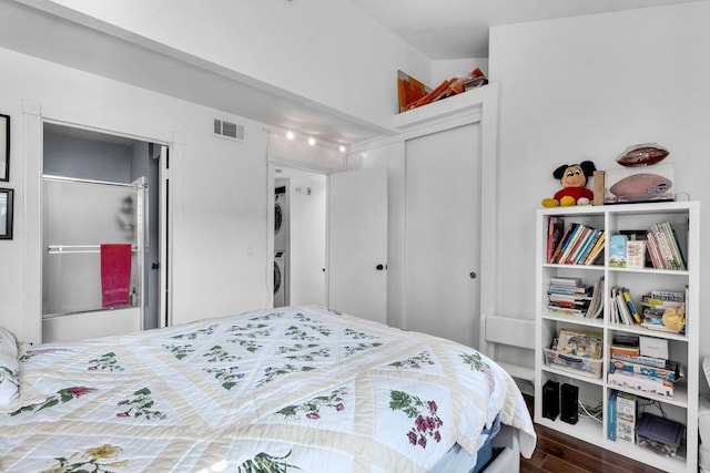 6323 Reseda Blvd Unit 13, Tarzana, CA 91335 - bedroom featuring stacked washer and clothes dryer, a closet, and dark wood finished floors
