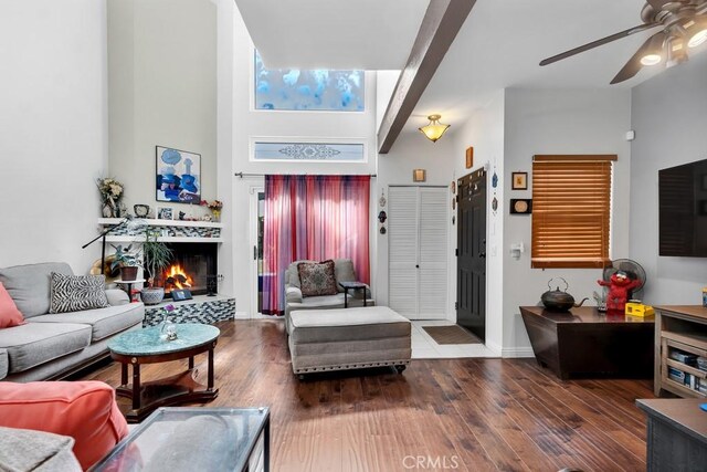 6323 Reseda Blvd Unit 13, Tarzana, CA 91335 - living room featuring a ceiling fan, a towering ceiling, wood finished floors, and a warm lit fireplace