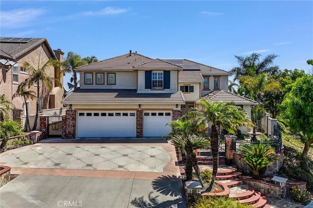 1411 W Boros Ct, La Habra, CA 90631 - view of front facade with concrete driveway, a garage, roof mounted solar panels, a tile roof, and a gate