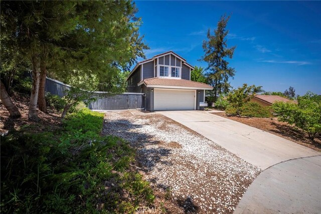 11359 Dole Ct, Riverside, CA 92505 - view of front facade featuring a garage, driveway, and a tile roof