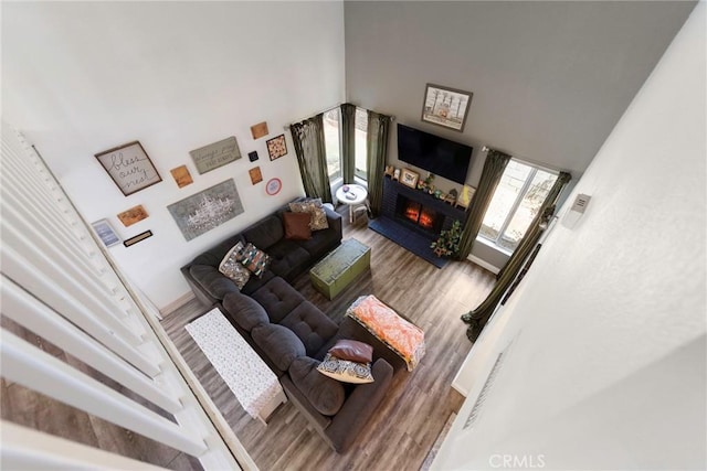 11359 Dole Ct, Riverside, CA 92505 - living area with a warm lit fireplace, wood finished floors, and a high ceiling