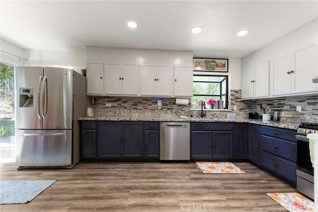 11359 Dole Ct, Riverside, CA 92505 - kitchen featuring appliances with stainless steel finishes, white cabinetry, decorative backsplash, light stone countertops, and recessed lighting