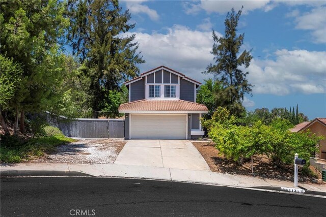 11359 Dole Ct, Riverside, CA 92505 - view of front facade with a tile roof, an attached garage, driveway, and stucco siding