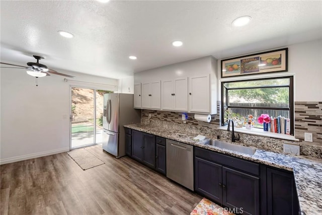 11359 Dole Ct, Riverside, CA 92505 - kitchen featuring stainless steel appliances, backsplash, ceiling fan, light wood-type flooring, and a textured ceiling