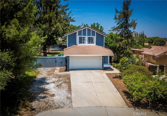 11359 Dole Ct, Riverside, CA 92505 - view of front of home with concrete driveway, an attached garage, a tiled roof, a gate, and stucco siding