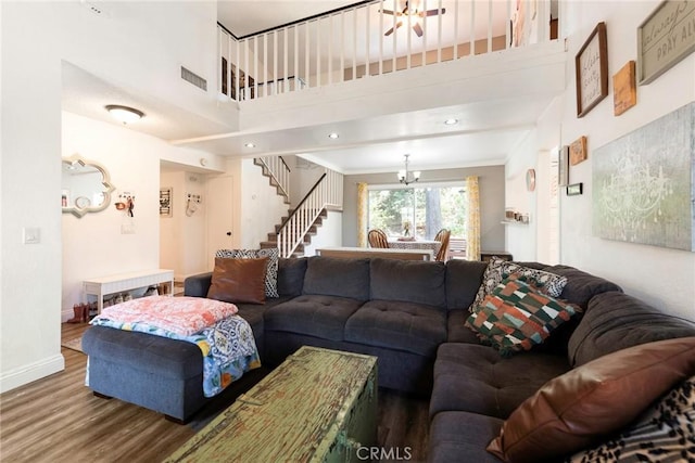 11359 Dole Ct, Riverside, CA 92505 - living room featuring wood finished floors, a chandelier, stairway, a towering ceiling, and ornamental molding
