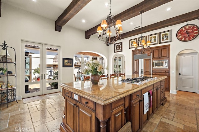 15 Sarteano Dr, Newport Coast, CA 92657 - kitchen featuring built in appliances, arched walkways, a chandelier, stone tile floors, and beamed ceiling