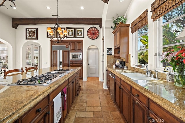 15 Sarteano Dr, Newport Coast, CA 92657 - kitchen featuring built in appliances, arched walkways, stone tile floors, hanging light fixtures, and recessed lighting
