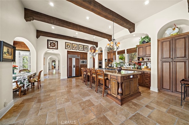 15 Sarteano Dr, Newport Coast, CA 92657 - kitchen featuring built in appliances, a chandelier, stone tile floors, a large island, and recessed lighting