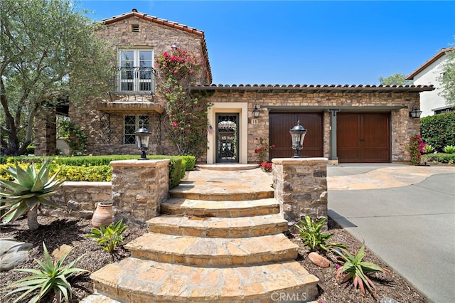 15 Sarteano Dr, Newport Coast, CA 92657 - mediterranean / spanish-style house with concrete driveway, a tile roof, stone siding, and a garage