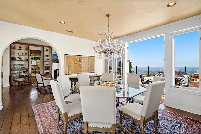 15 Sarteano Dr, Newport Coast, CA 92657 - dining area with arched walkways, dark wood finished floors, a chandelier, crown molding, and recessed lighting