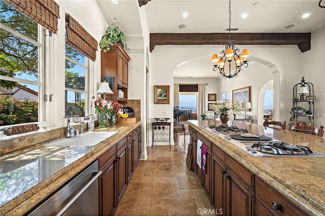 15 Sarteano Dr, Newport Coast, CA 92657 - kitchen featuring white cooktop, dishwasher, arched walkways, stone tile flooring, and a chandelier