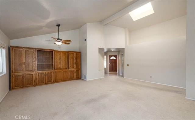 1144 Jasmine St, Redlands, CA 92374 - unfurnished living room featuring light colored carpet, a ceiling fan, a skylight, beamed ceiling, and high vaulted ceiling
