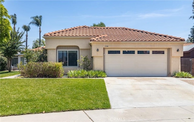 1144 Jasmine St, Redlands, CA 92374 - mediterranean / spanish-style house featuring stucco siding, a garage, a front yard, driveway, and a tile roof