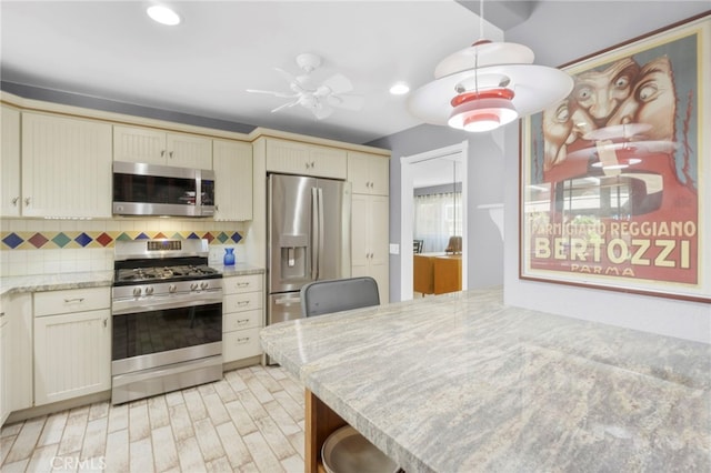 21845 Tumbleweed Cir, Lake Forest, CA 92630 - kitchen with stainless steel appliances, backsplash, recessed lighting, cream cabinets, and light wood-type flooring