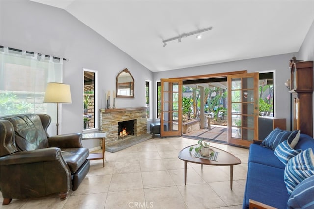 21845 Tumbleweed Cir, Lake Forest, CA 92630 - living area featuring vaulted ceiling, healthy amount of natural light, light tile patterned flooring, french doors, and a stone fireplace