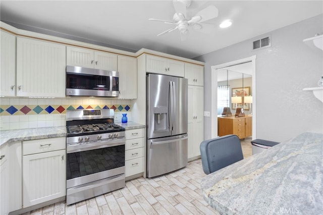 21845 Tumbleweed Cir, Lake Forest, CA 92630 - kitchen with stainless steel appliances, backsplash, a ceiling fan, light wood-style floors, and light stone countertops