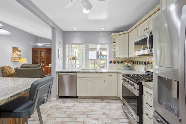 21845 Tumbleweed Cir, Lake Forest, CA 92630 - kitchen featuring appliances with stainless steel finishes, ceiling fan, decorative backsplash, light stone counters, and recessed lighting